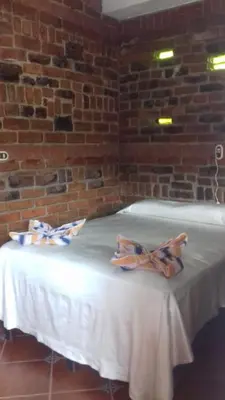 a table with a white table cloth and a brick wall at San Fernando in Concepción de Ataco