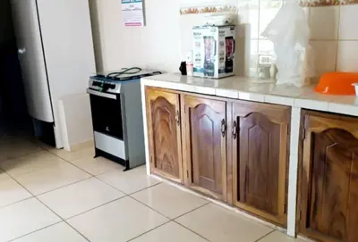 a kitchen with wooden cabinets and a refrigerator at Home with Swimming pool, Wi-FI in Ahuachapán