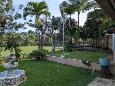 a tennis court in a yard with palm trees at Home with Swimming pool, Wi-FI in Ahuachapán