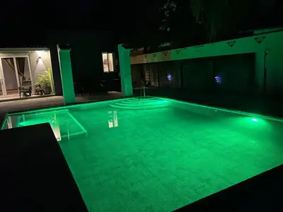 a swimming pool at night with green lighting at Quinta Temiki in San Pedro Masahuat