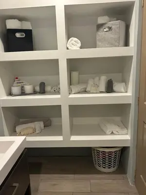 a pantry with white shelves with towels at Quinta Temiki in San Pedro Masahuat