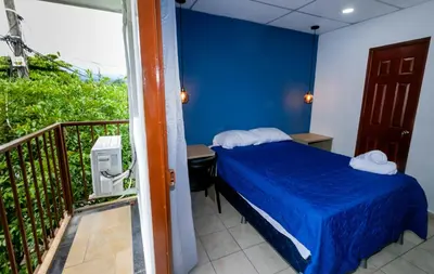 a bedroom with a bed and a balcony at Friendly House in Nueva San Salvador