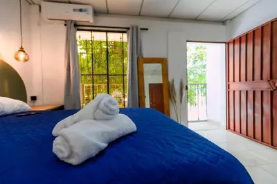 a room with a blue bed with towels on it at Friendly House in Nueva San Salvador