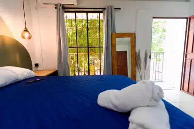 a bedroom with a blue bed with a stuffed animal on it at Friendly House in Nueva San Salvador