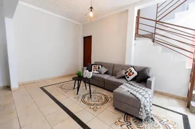 a living room with a couch and a table at Friendly House in Nueva San Salvador