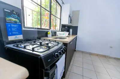 a kitchen with a stove and a sink at Friendly House in Nueva San Salvador