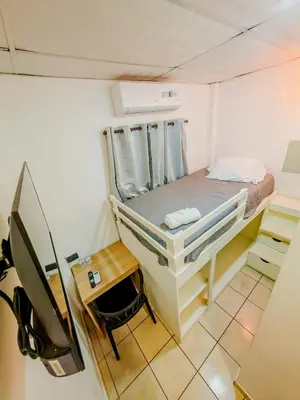 a small room with a bunk bed and a desk at Friendly House in Nueva San Salvador