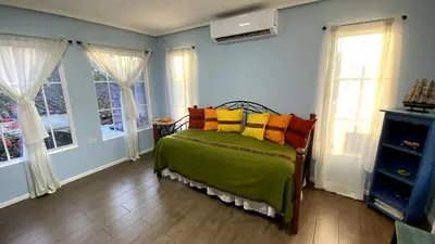a bedroom with a bed with colorful pillows on it at Chalchuapa’s Haven in Chalchuapa