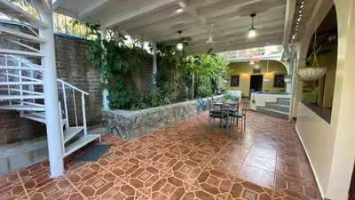 an indoor patio with tables and chairs and plants at Chalchuapa’s Haven in Chalchuapa