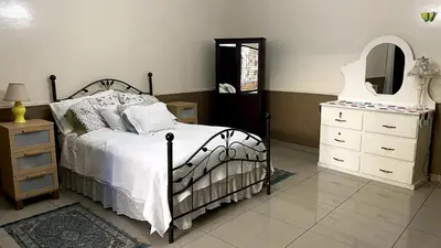 a bedroom with a bed and a dresser and a mirror at Chalchuapa’s Haven in Chalchuapa