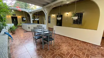 a patio with a table and chairs in a house at Chalchuapa’s Haven in Chalchuapa