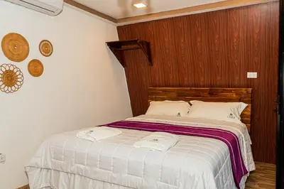 a bedroom with a bed with two towels on it at Hacienda Rubí Club & Resort in San Miguel