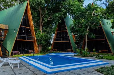 a swimming pool in front of a building with trees at Hacienda Rubí Club & Resort in San Miguel