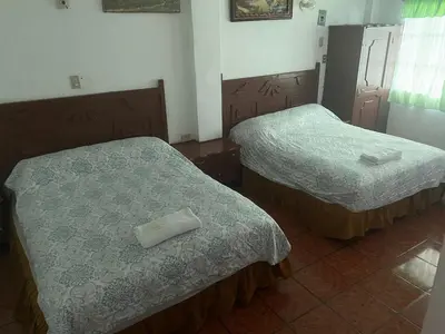 two beds in a hotel room with towels on them at Hotel Inn El Guanaco in San Miguel