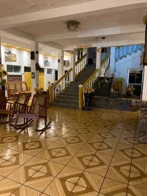 a lobby with chairs and stairs in a building at Hotel Inn El Guanaco in San Miguel