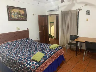 a bedroom with a bed and a table and a desk at Hotel Inn El Guanaco in San Miguel