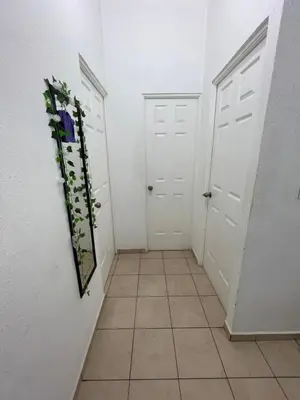 a hallway with two white doors and a tile floor at Gabby House in Sitio del Niño