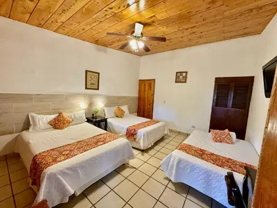 a bedroom with two beds and a ceiling at Hotel y Restaurante Alicante de Montaña, El Salvador in Los Tablones