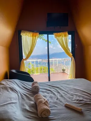 a bedroom with a bed with a view of the ocean at Las Terrazas de el Alto in Chalatenango