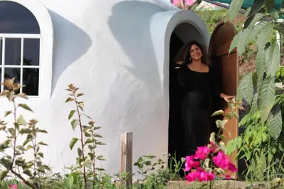 a woman standing in the doorway of a play house at Las Terrazas de el Alto in Chalatenango