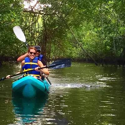a man and a woman in a kayak on a river at Puerto Barillas in Bahia de Jiquilisco