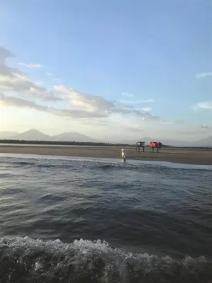 a person standing on the beach near the water at Puerto Barillas in Bahia de Jiquilisco