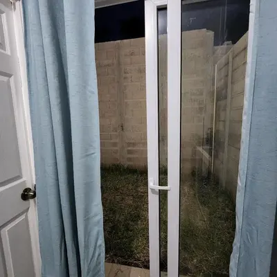 an open door to a yard with blue curtains at Apartamento Familiar in Santa Ana