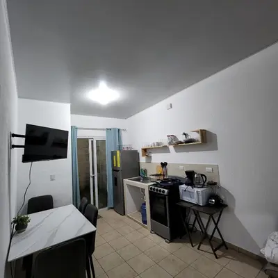 a kitchen with a stove and a table and a counter top at Apartamento Familiar in Santa Ana