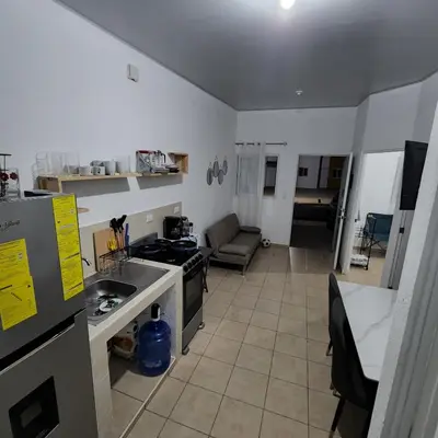 a kitchen with a stove and a couch in a room at Apartamento Familiar in Santa Ana