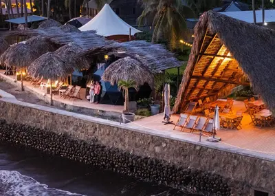 a restaurant with chairs and umbrellas on a beach at Almare Zonte - BeachFront Glamping Hotel in El Zonte