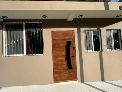 a house with a wooden door and two windows at Tiny Room El Mangal B&B in Suchitoto
