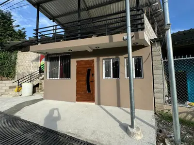 a small house with a brown door on it at Tiny Room El Mangal B&B in Suchitoto
