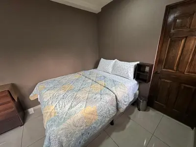 a small bedroom with a bed and a television at Tiny Room El Mangal B&B in Suchitoto