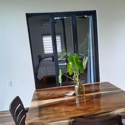 a wooden table with a vase with a plant on it at Surf Lodge El Carrizal-Punta Mango in La Periquera
