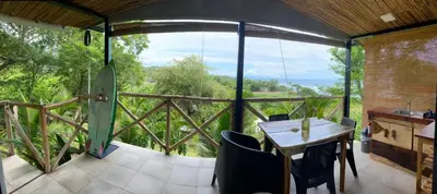 a room with a table and chairs on a balcony at Surf Lodge El Carrizal-Punta Mango in La Periquera
