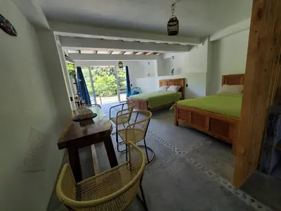 a bedroom with two beds and a table and chairs at Wayo loft en Playa El Tunco Surf City in Tamanique