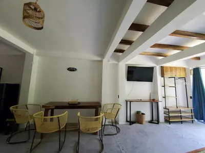 a dining room with chairs and a table and a screen at Wayo loft en Playa El Tunco Surf City in Tamanique