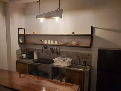a kitchen with a sink and a shelf with utensils at Wayo loft en Playa El Tunco Surf City in Tamanique