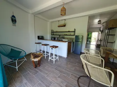 a kitchen with chairs and a table and a counter at Wayo loft en Playa El Tunco Surf City in Tamanique