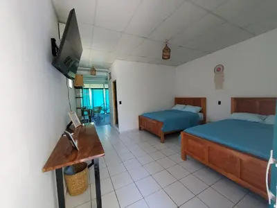 a bedroom with two beds and a flat screen tv at Wayo loft en Playa El Tunco Surf City in Tamanique
