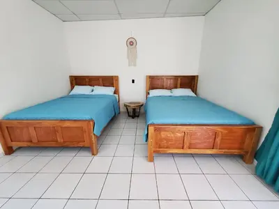 two beds sitting next to each other in a room at Wayo loft en Playa El Tunco Surf City in Tamanique