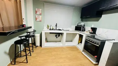a kitchen with a stove and a counter with stools at Muy cerca de playas y miradores muy accesible a la ciudad y comercios in La Unión