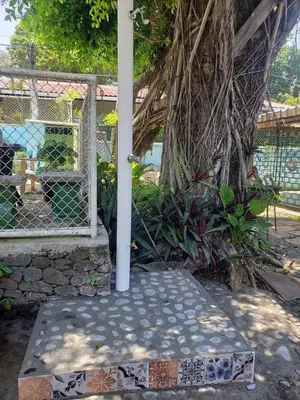 a porch with a gate and a bench with tiles at Hostal Tia Reyna in El Zonte