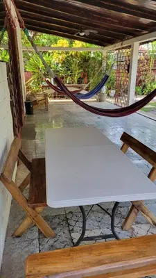 a white bench and a hammock in a porch at Hostal Tia Reyna in El Zonte