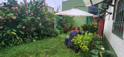 a man and woman sitting on a chair in a garden at D Origen House APANECA in Apaneca