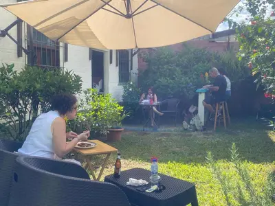 a woman sitting at a table under an umbrella at D Origen House APANECA in Apaneca