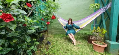 a woman sitting on a hammock in a garden at D Origen House APANECA in Apaneca