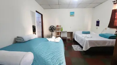 a room with two beds and a blue blanket at D Origen House APANECA in Apaneca