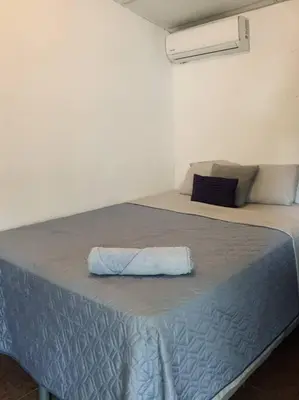 a bed with a blue blanket on top of it at Casa Maracuyá in La Libertad