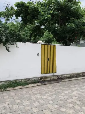 a white fence with a yellow door on it at Casa Maracuyá in La Libertad